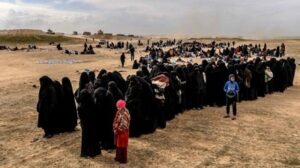 ISIS militants' women and children line up for detention processing.