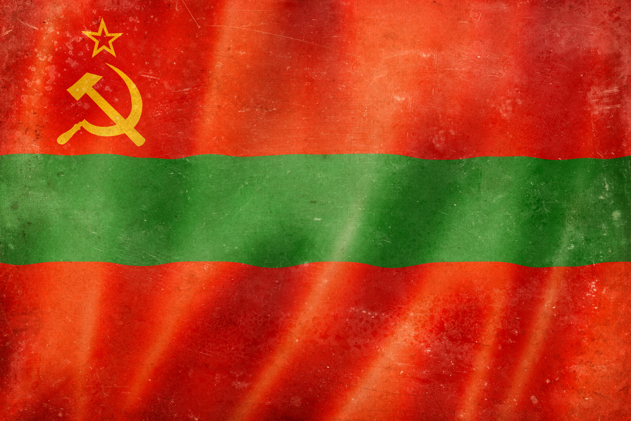 The Transnistria flag. Two thick red stripes with a thinner horizontal green stripe in the center. At the top left is a hammer and sickle.