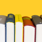 A row of books with a yellow background.
